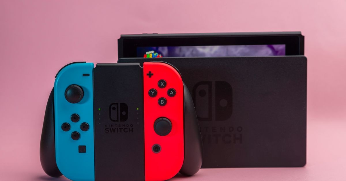 Nintendo names Prince of Persia: The Lost Crown as its latest Switch Online Game Trial Close-up of Nintendo Switch console with red and blue Joy-Con controllers on pink background.