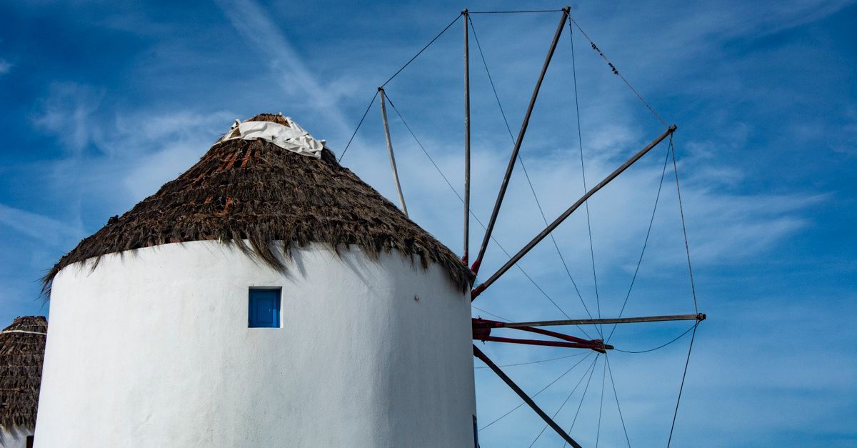 Mykonos in July: A Travel Guide to Peak Season on the Island of the Winds Beautiful view of a traditional windmill in Mykonos, Greece against a blue sky.