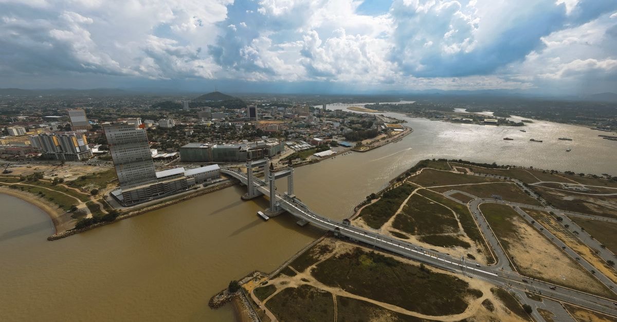Kota Kuala Muda Travel Guide: Planning Tips, Costs and Things to Do Scenic aerial view of Kuala Terengganu city and bridge under a dramatic cloudy sky.