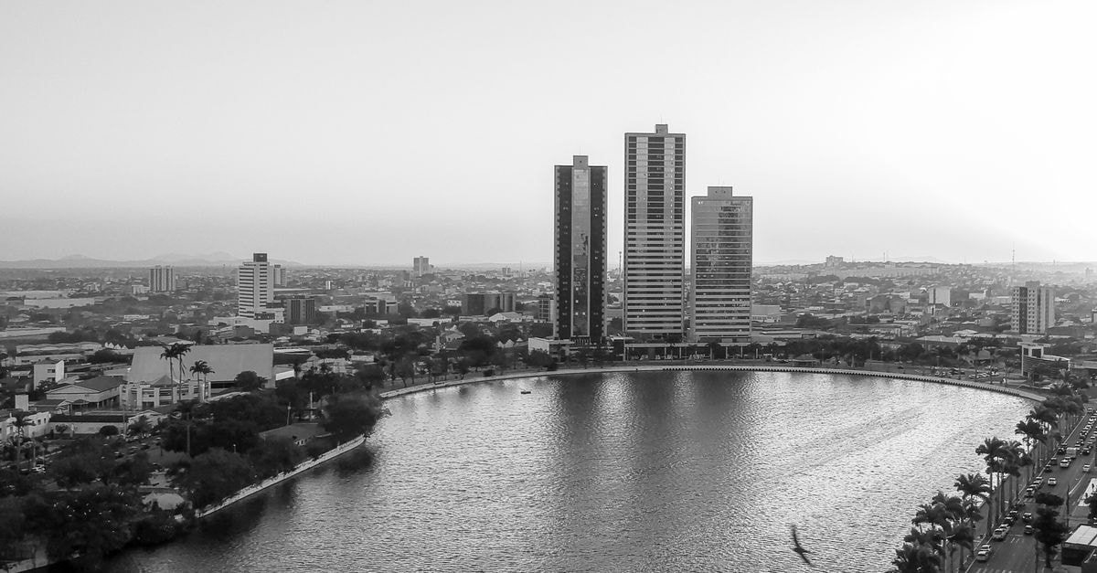 Stunning aerial cityscape of Campina Grande, Brazil in black and white showcasing tall buildings and a tranquil lake.