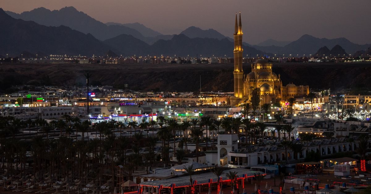 Nighttime scene of an illuminated mosque and cityscape in Sharm El Sheikh, Egypt.