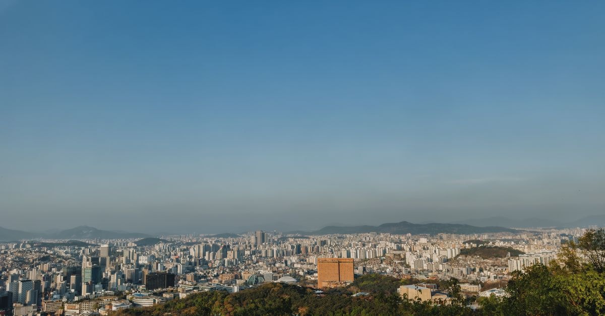 Hotel Cristânia in Camama: A Pit Stop on the Via Expressa Expansive view of Seoul's skyline from a hilltop with clear blue sky.