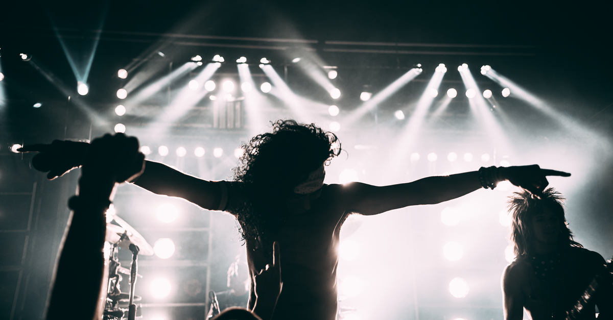 Energetic rock band performance with striking stage lights and silhouettes.