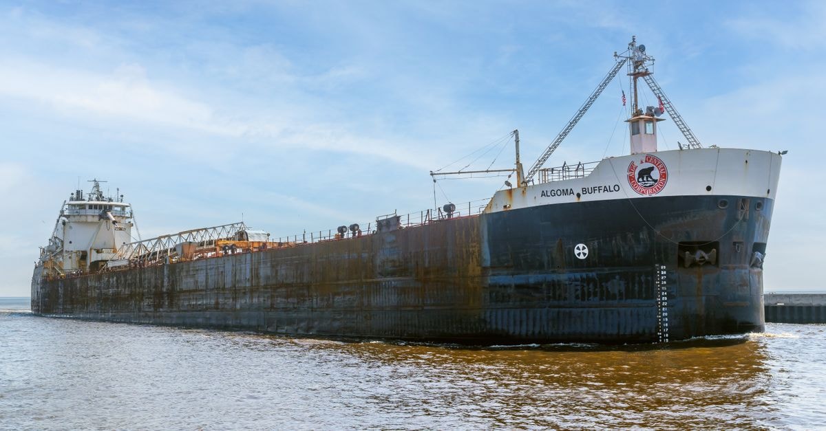 US steel imports drop sharply under tariffs as Algoma pivots home and Aperam posts strongest quarter in four years A massive cargo ship travels through open waters under a bright sky.
