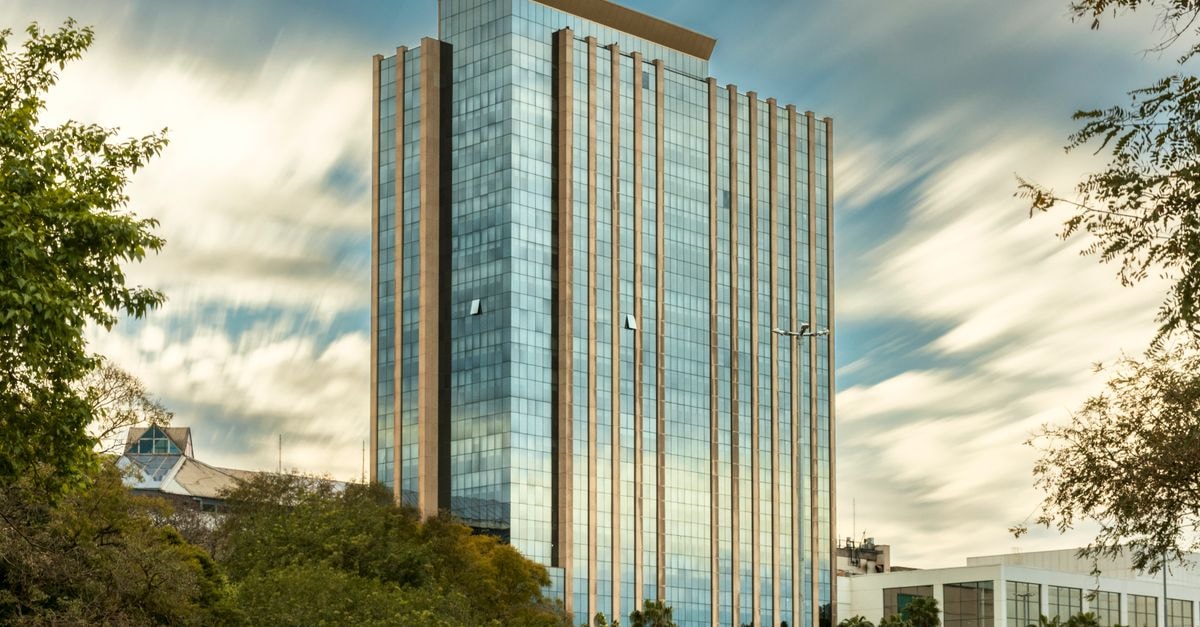 Skyscraper with reflective glass facade in Porto Alegre on a cloudy day.