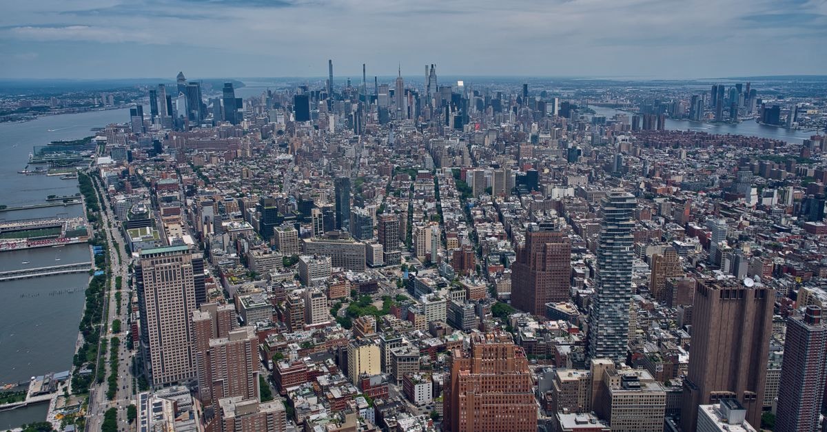 Manhattan Travel Guide for August 2026: Planning Tips and Costs Breathtaking aerial view of the Manhattan skyline with the Hudson River, showcasing New York City's dense architecture.