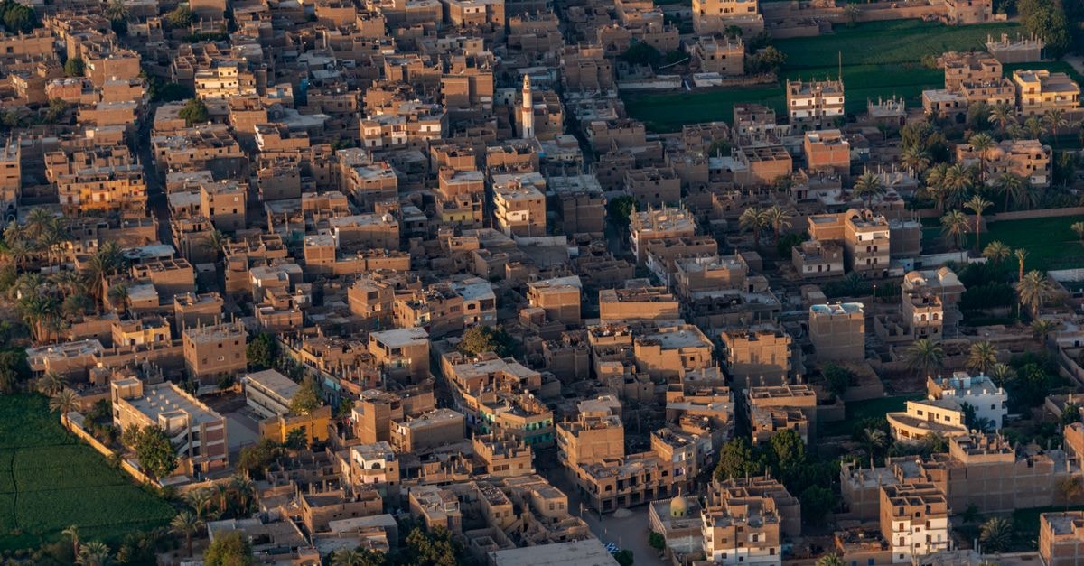 Gaochang District Stay in Turpan, China: A Silk Road Address Aerial shot of a densely packed Middle Eastern town with traditional buildings.