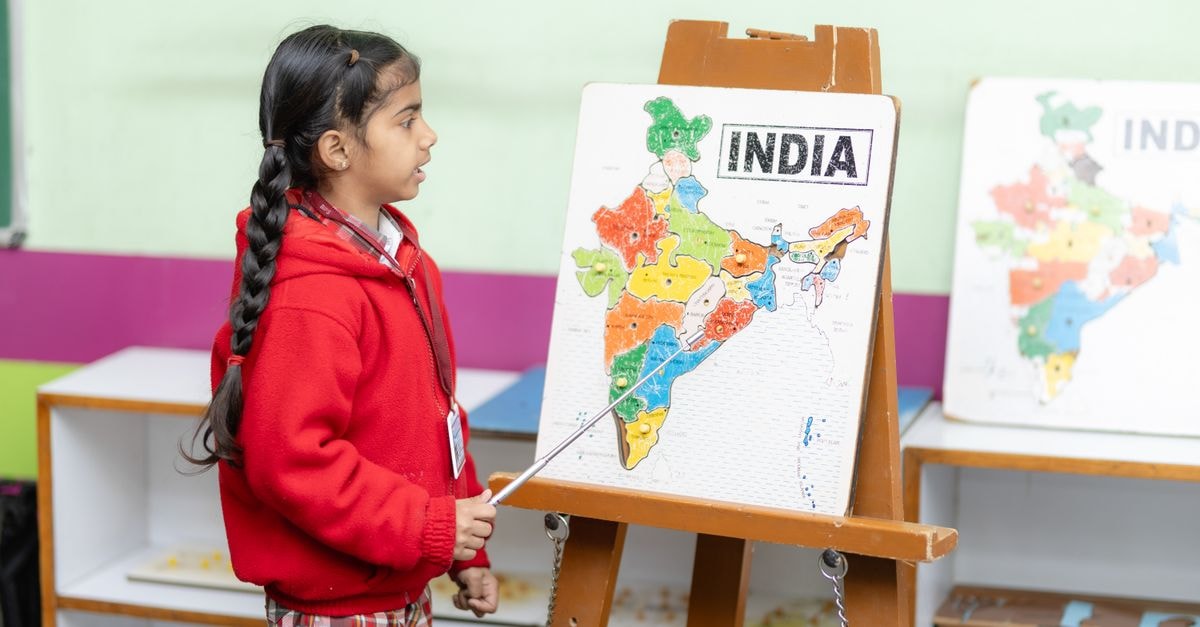 Eqbal Inn in Patiala: Royal City Stay Near Heritage Landmarks Young student points to India map in a classroom, fostering education.