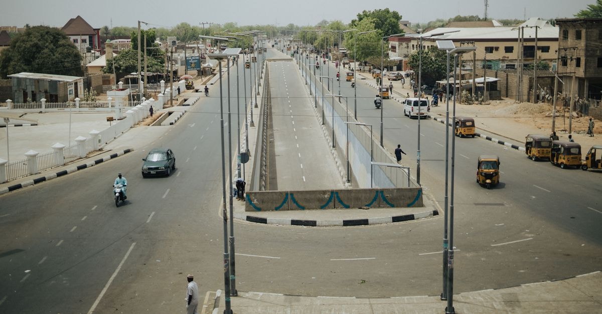 Tamale travel guide: Northern Ghana's warmhearted crossroads A busy city intersection with vehicles and commuters under a clear sky, showcasing urban life.