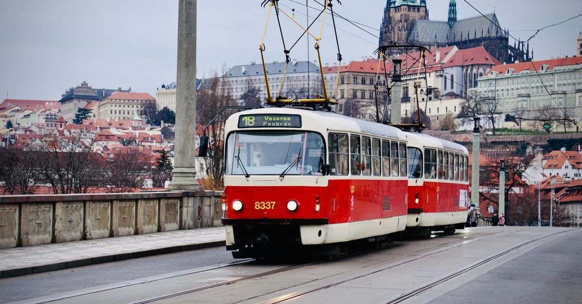 Kochi Travel Guide: Castles, Tram Rides, and Pacific Coast Flavors Vintage Prague tram on a city street with St. Vitus Cathedral in the background, capturing urban charm.