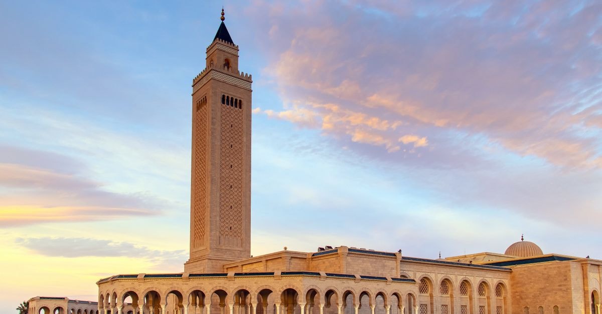 Tunis Travel Guide: A Calm Look at Tunisia's Underrated Capital Stunning exterior of a mosque in Tunis, Tunisia, showcasing elegant arches and a tall minaret at sunset.