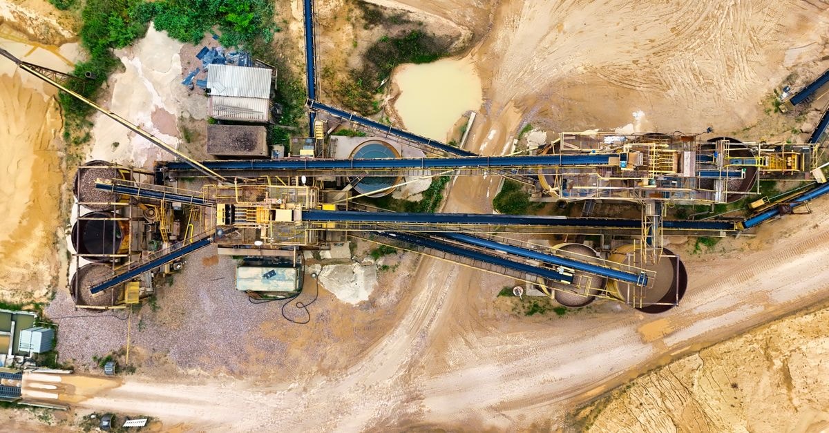 Silver pushes to multi-month highs on weaker US dollar as bullion complex rallies Top-down view of a sprawling industrial mining site featuring heavy machinery and detailed terrain.