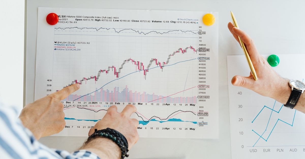 Novartis India shares hit record after ₹1,250 crore Minipress deal with Pfizer Two professionals analyze stock market graphs with a focus on finance and data trends.