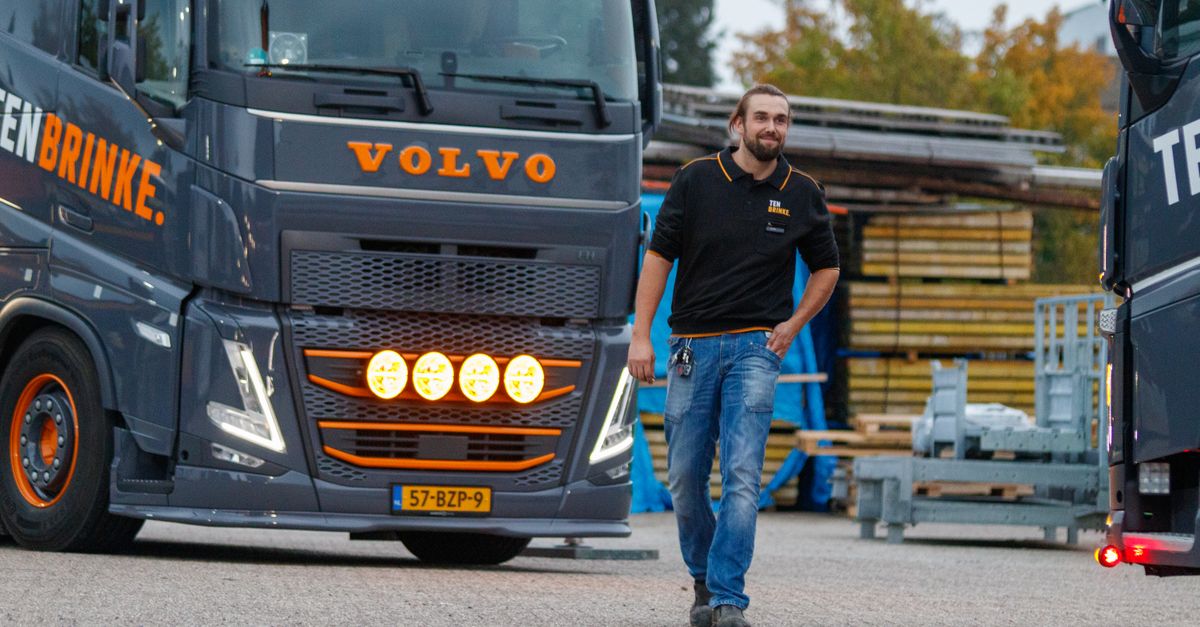 Volvo Rolls Out Australia's First OEM Electric Trucks as Ford, Apple, Mitsubishi and VW-Rivian Cases Shape EV Week Truck driver walking near a Volvo truck in an industrial area during the day, showcasing logistics and transportation.