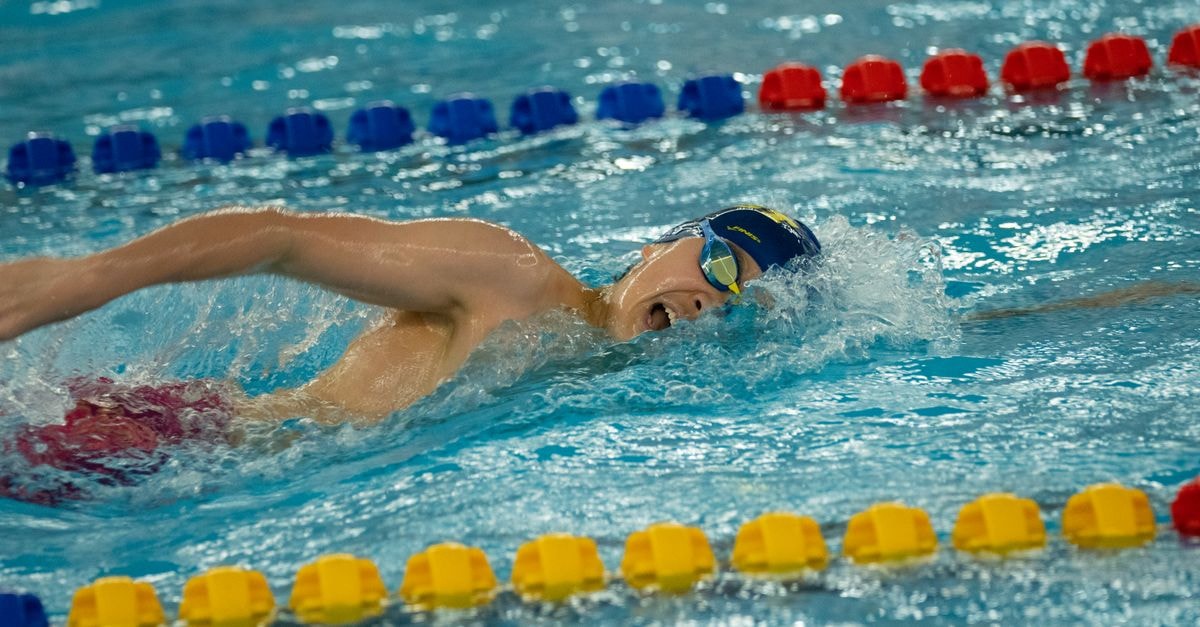 Teens Mijatovic and Mintenko Claim 400m Freestyle Titles at U.S. Swimming Nationals Swimmer performing freestyle stroke in an indoor pool during competition.
