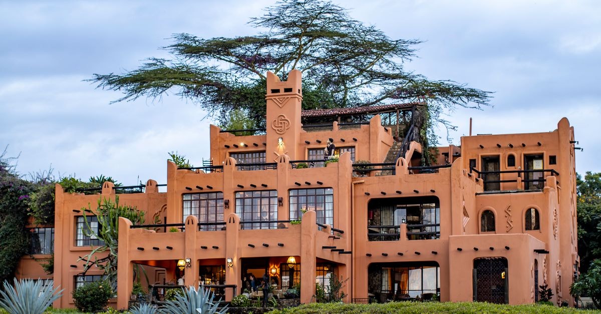 Beautiful adobe-style architecture surrounded by vibrant greenery, captured at dusk.