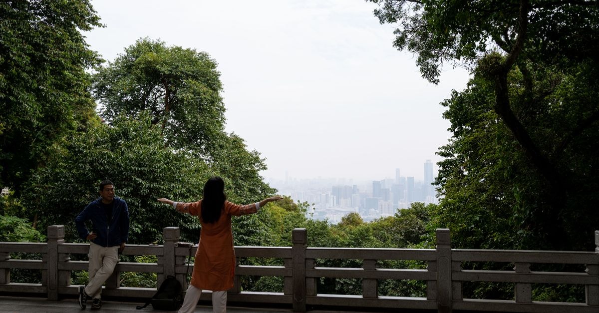 兩位旅客在中國廣州一座公園裡欣賞城市美景。