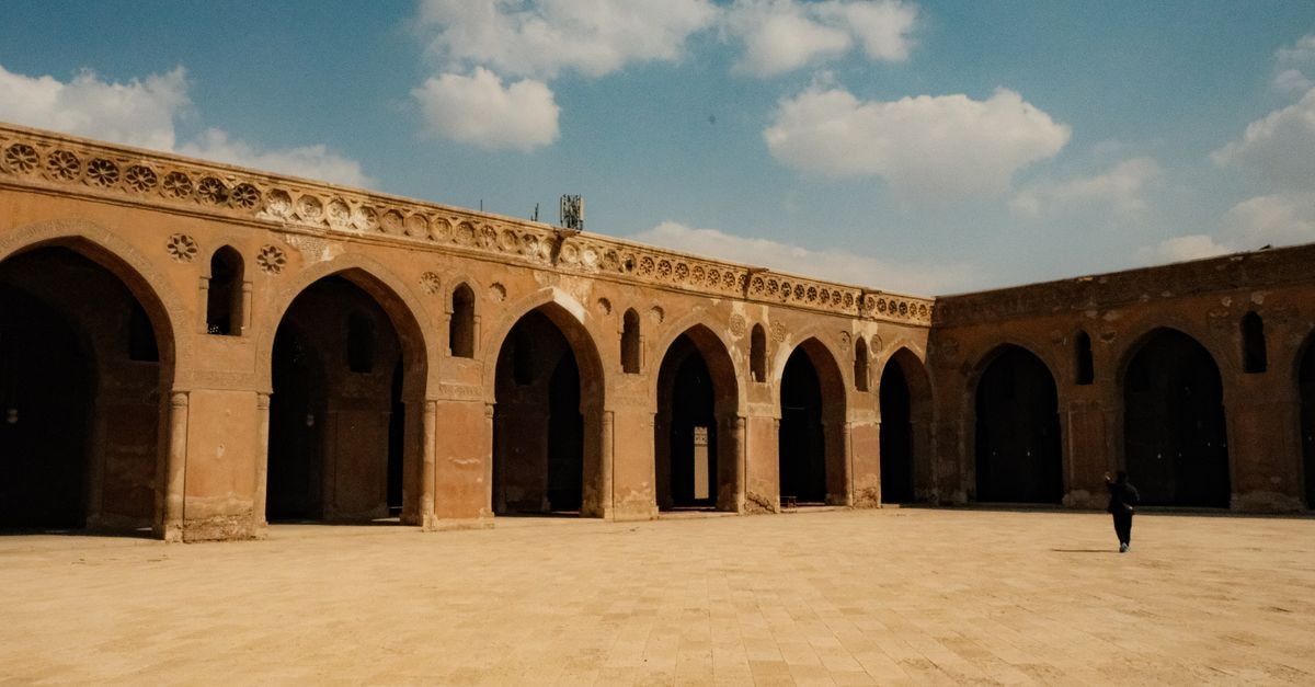 Walking Baghdad: A First-Timer's Travel Guide to the Tigris Capital Stunning view of a historical courtyard with arched doorways and clear sky.