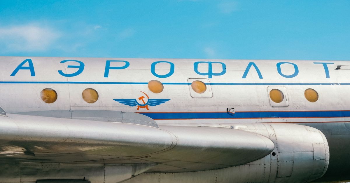 Close-up of Aeroflot Soviet airliner, highlighting historical aviation details against a clear blue sky.