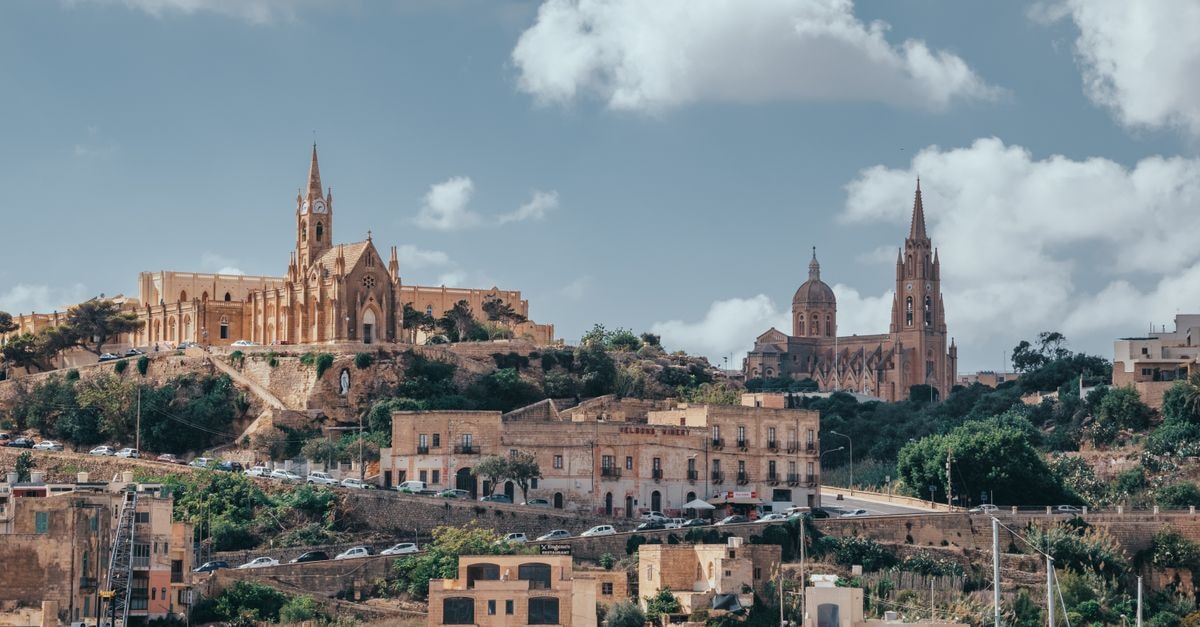 Verdala Wellness Hotel in Rabat: A Quiet Base Next to Mdina Majestic historic churches set against a Maltese hillside with scenic sky and clouds.