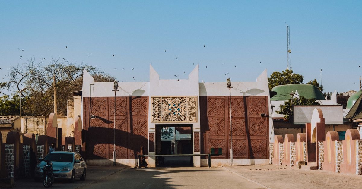 N'Djamena Travel Guide: Planning Tips, Costs and Things to Do Rustic architectural facade under blue sky in sunlit city environment.