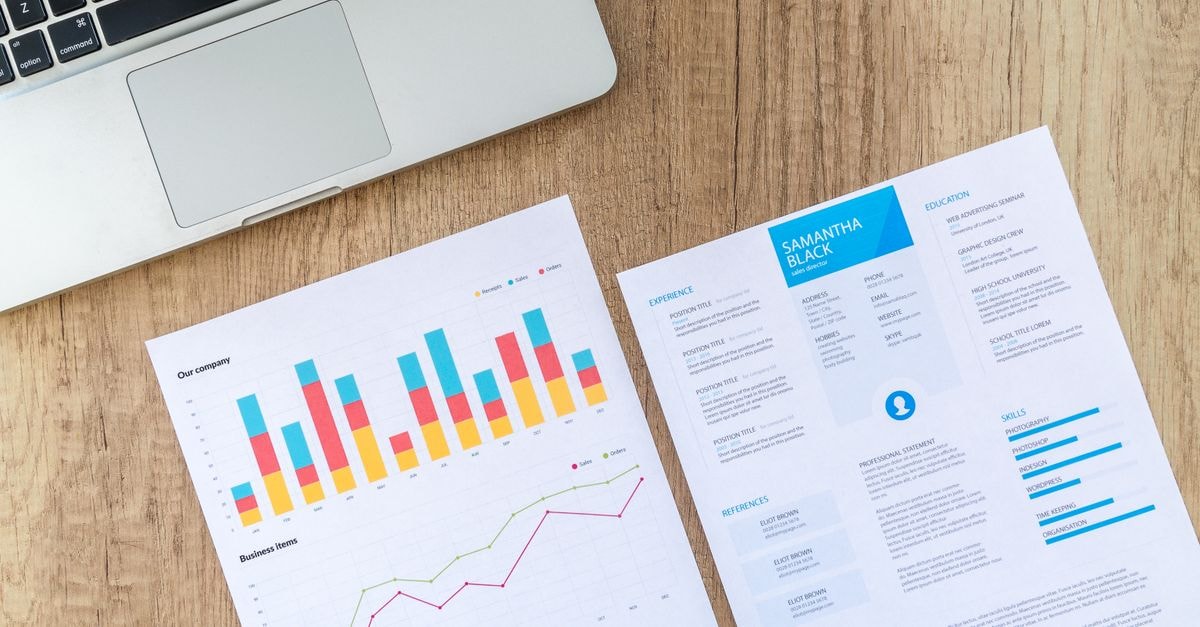 STB Resumes Union Pacific-Norfolk Southern Merger Review as Fuel-Surcharge Filing Raises Eyebrows Top view of a laptop, charts, and resume on a wooden desk, showcasing business analysis and job application.