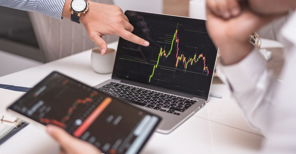 商務專業人士在筆記型電腦與平板電腦上分析加密貨幣市場趨勢。