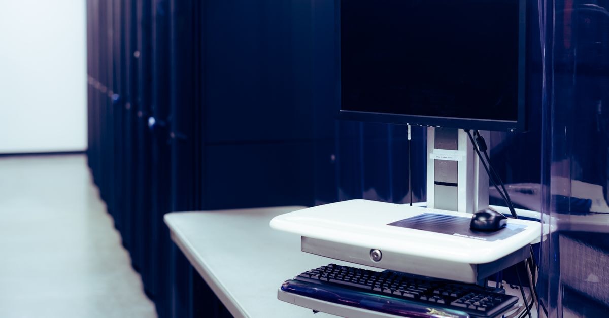 HPE and Oracle Announce AI Data Center Deal as OpenAI Pact Spurs Fears Over Oracle's Risk Profile Contemporary computer with black screen placed on stand near row of server steel racks in data center