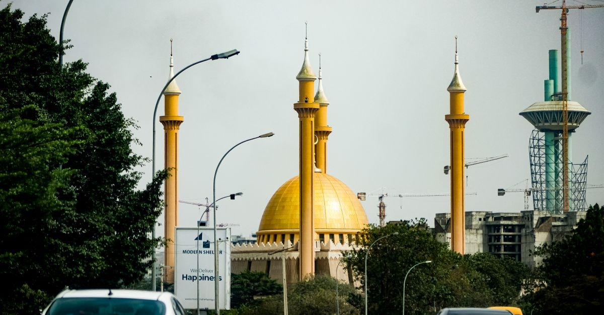 Abuja, Nigeria Travel Guide: Where Modern Planning Meets Wide Skies A bustling city street in Abuja featuring the iconic National Mosque and cars in traffic.