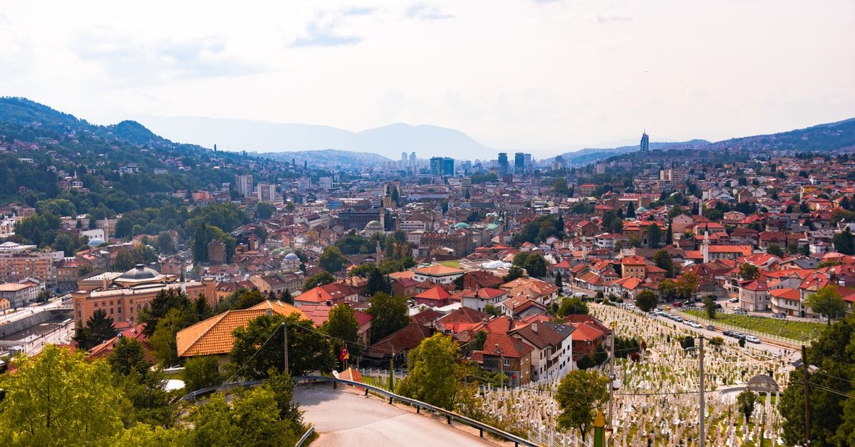 Hotel Kicevo in Kicevo: A Quiet Stop Near Mountain Monasteries Aerial view of Sarajevo, showcasing cityscape, red rooftops, and distant mountains.