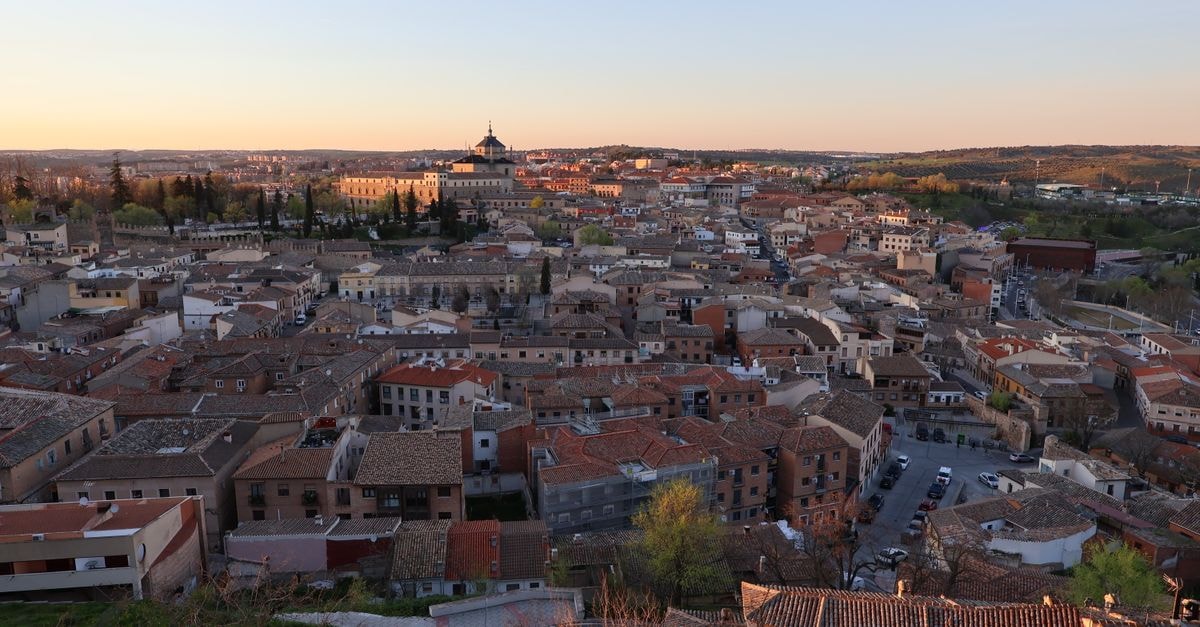 Mao Travel Guide: A Quiet Valverde City Worth a Slow Stop Stunning aerial view of Toledo, Spain during a vibrant sunset, showcasing historic architecture.