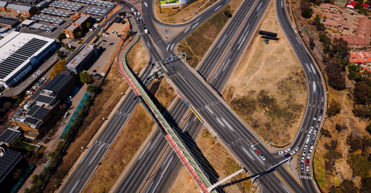 Roodepoort Travel Guide: Climate, Transit, and Local Gems Aerial view capturing a bustling highway intersection in Sandton, Gauteng with flowing traffic.