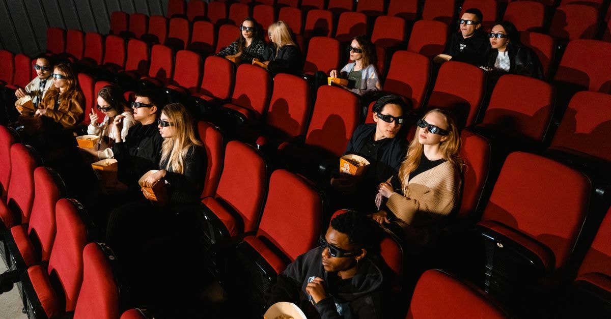 Shah Rukh Khan confirms 'King' release stays on December 24, addresses injuries and VFX work People enjoying a film in a cinema, wearing 3D glasses and eating popcorn.