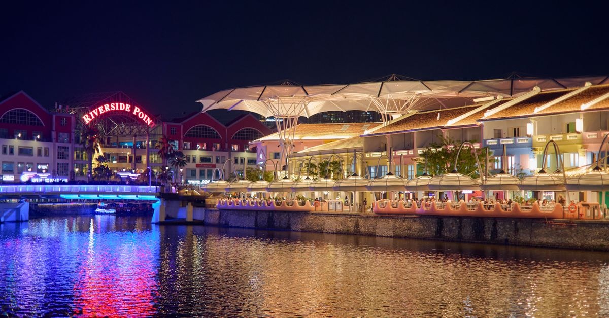 Jurong West Travel Guide: Planning Tips, Costs and Things to Do Night view of Riverside Point with colorful reflections over water.