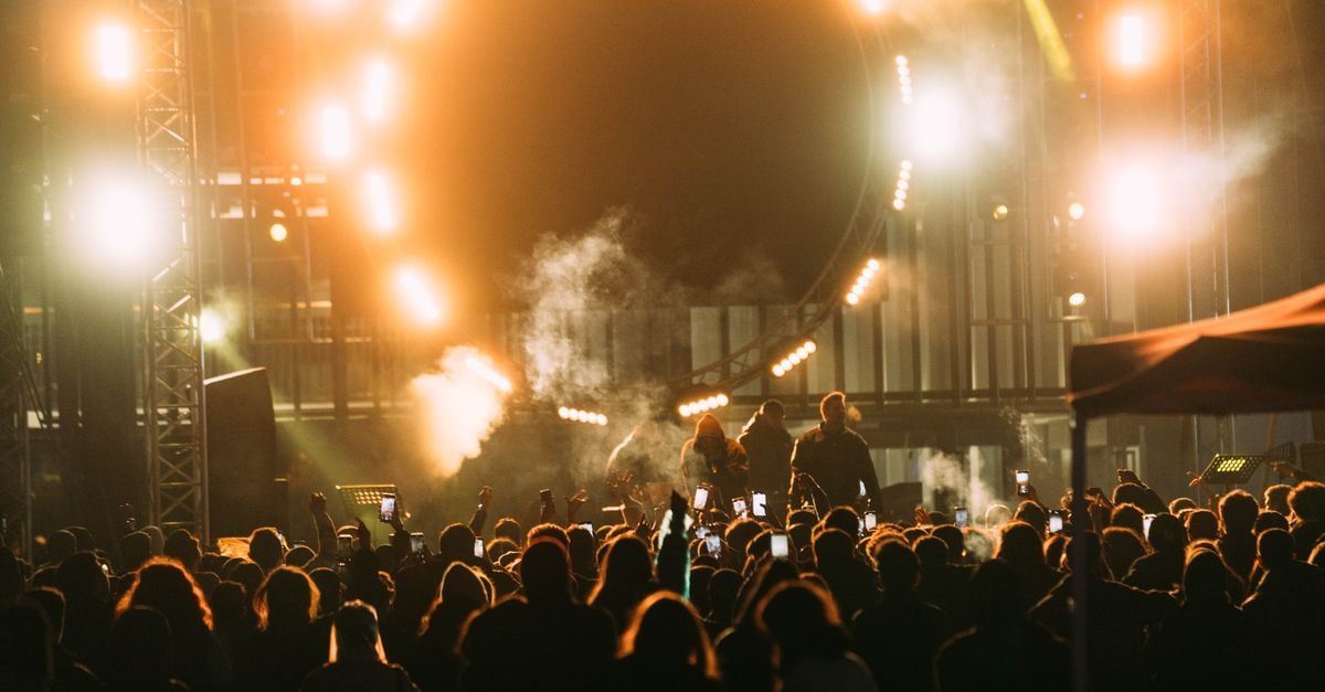 Captivating live concert scene with crowd and bright stage lights at night.