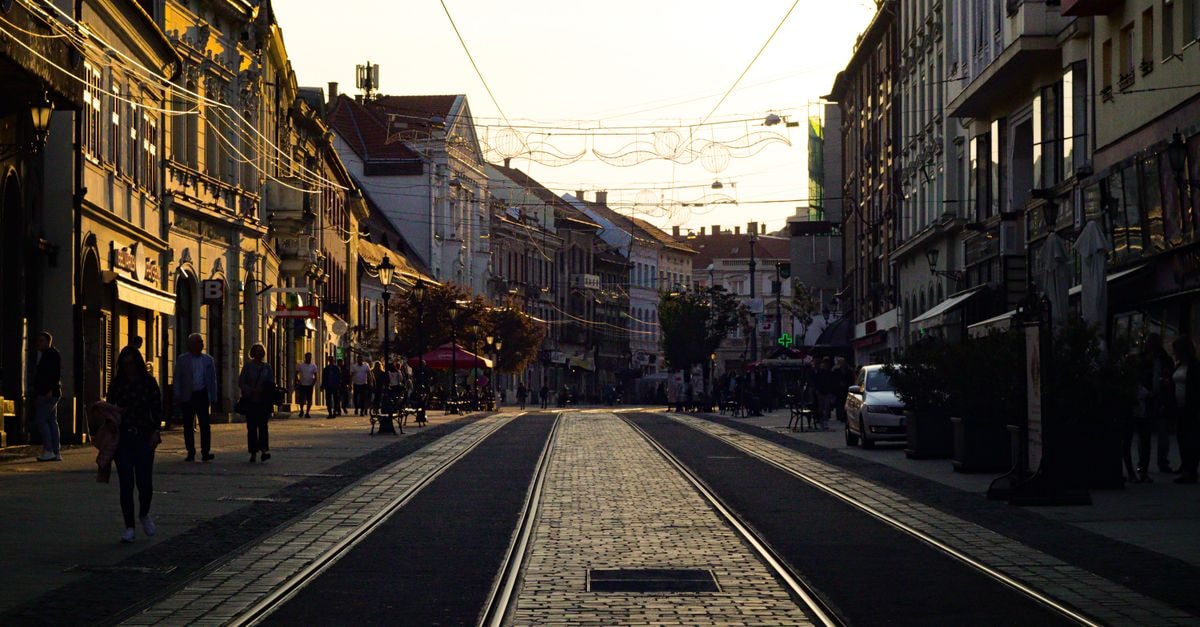 A Quiet Discovery: Things to Do in Debrecen, Hungary Busy city street in Miskolc, Hungary with tram tracks and pedestrians during the day.