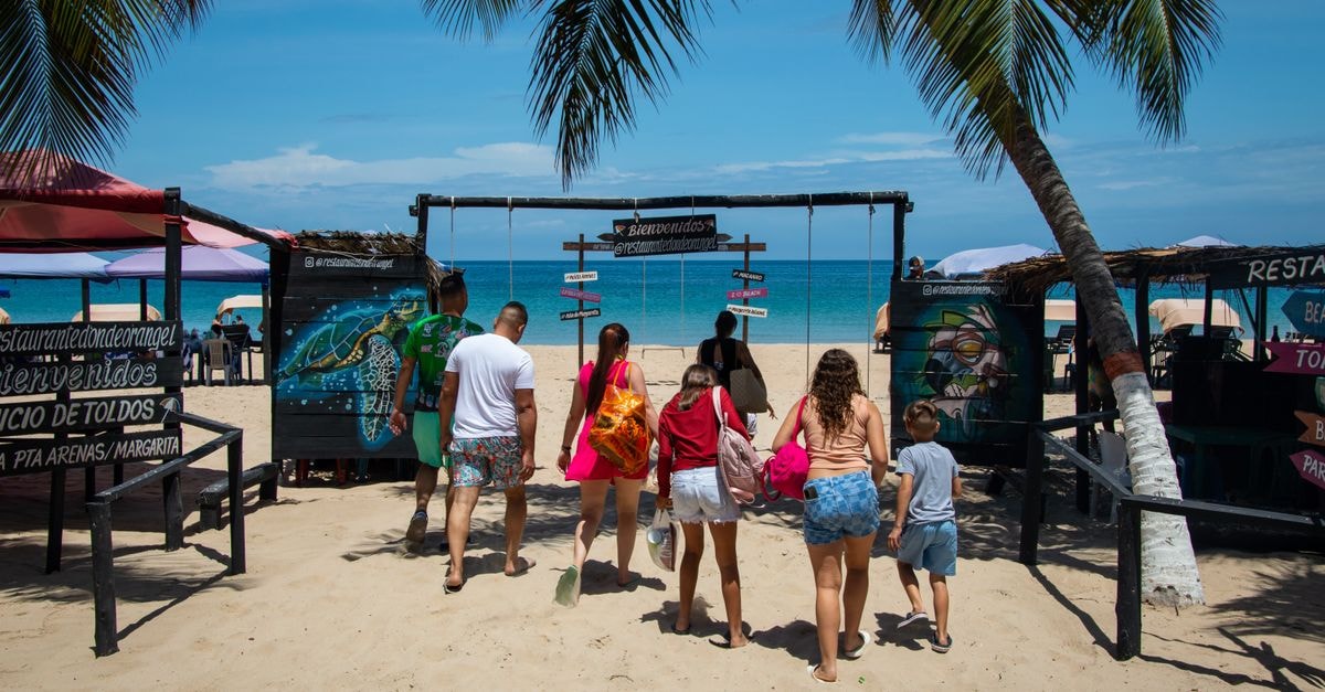 Discover Cumaná, Venezuela: A Travel Guide to Coastal Charm A family entering a tropical beach resort on a sunny summer day, perfect for vacations.