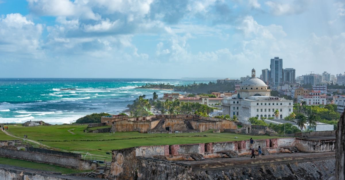 Posada Nativa Lizard House, San Andrés: Blue Lizards and a Plaza Locale Explore the stunning view of San Juan's historic fort with ocean backdrop under a vibrant sky.