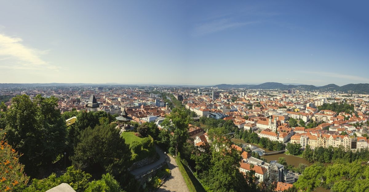 A stunning aerial shot showcasing the sprawling cityscape of Graz, Austria with its mix of greenery and urban architecture.