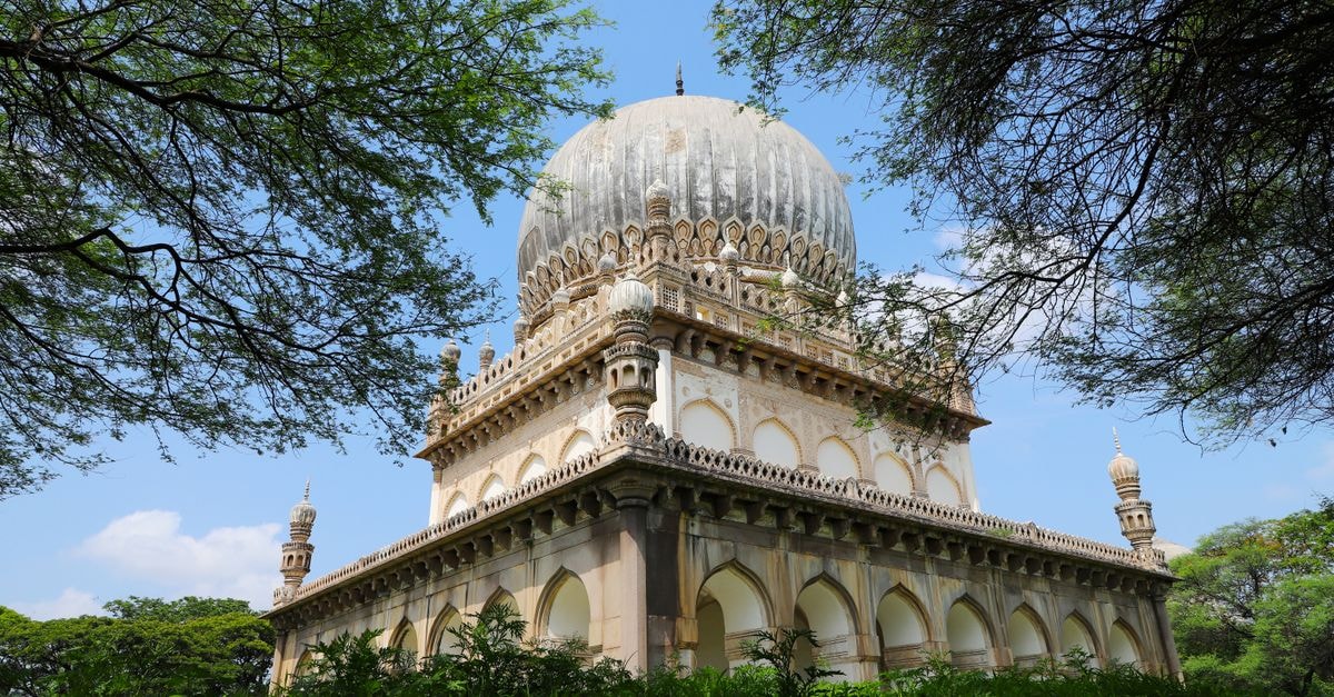 Hyderabad Travel Guide: Pearls, Palaces, and Everyday Magic Majestic Qutb Shahi Tomb amidst greenery, showcasing Islamic architecture in bright daylight.