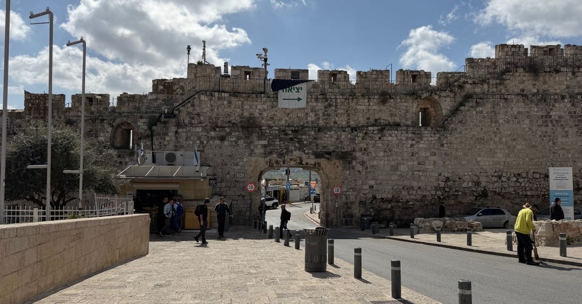 A Thoughtful Jerusalem Travel Guide for Slow, Curious Visitors View of historic Jaffa Gate in Jerusalem's Old City with pedestrians and clear blue sky.