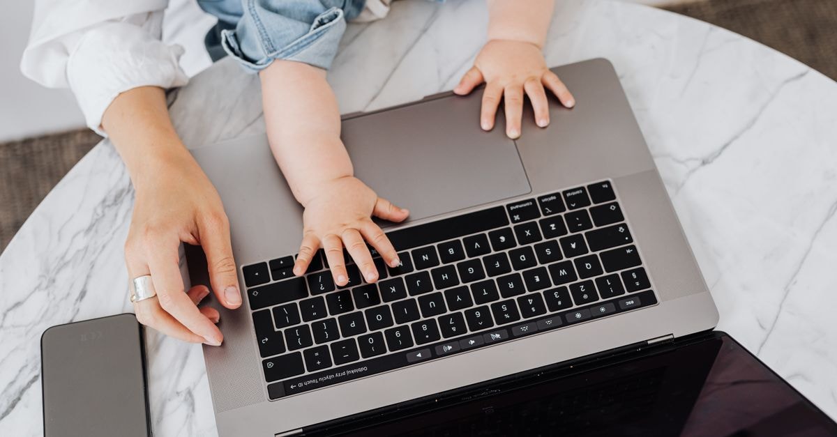 Ashgabat Travel Guide: White Marble, Bright Glare, Careful Photography Top view of a parent and a child's hands on a laptop keyboard, symbolizing digital learning.