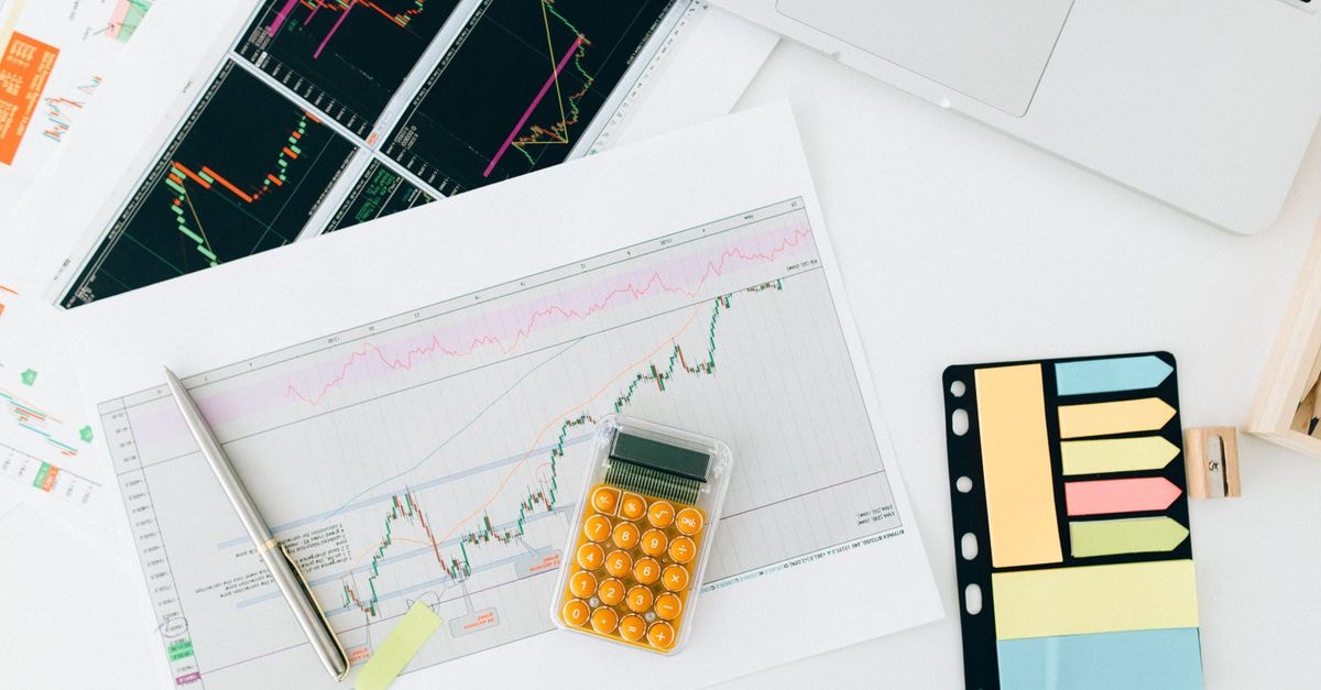 RBI approves LIC to acquire up to 9.99% stake in ICICI Bank within a year Flat lay of financial charts and tools on office desk, ideal for business and finance concepts.