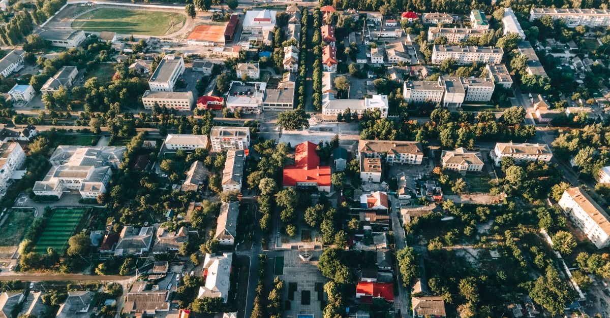 Platon Hotel in Kherson: A Quiet Stay on Myru Street Aerial panorama of a town featuring buildings, streets, and green landscapes from above.