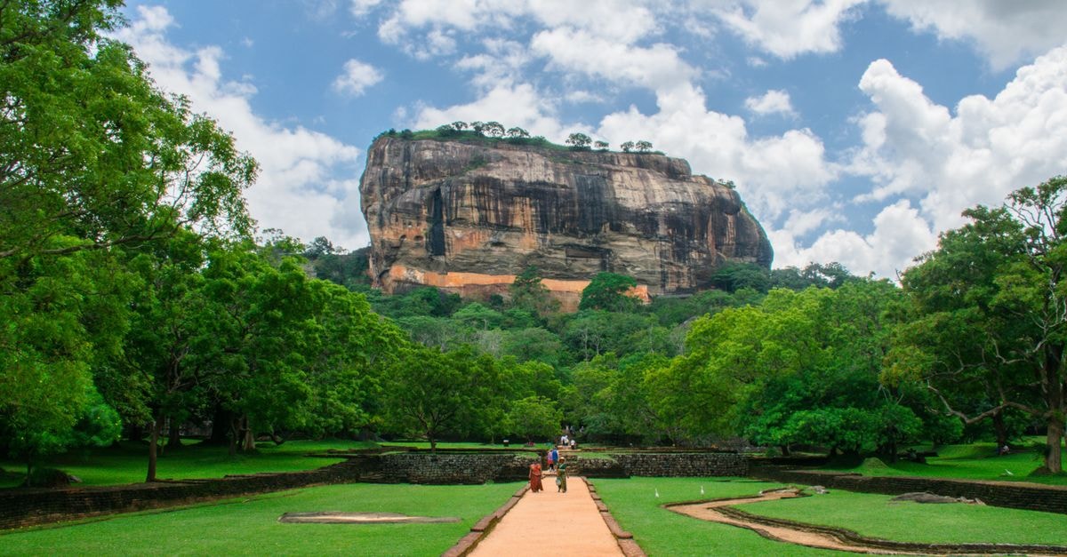 Sigiriya Rock Fortress towering over lush green landscape, a famous UNESCO World Heritage site in Sri Lanka.