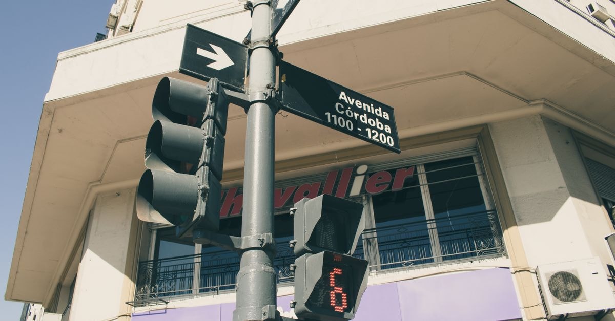 Hostel Aldea, Córdoba: A Village-Style Hostel Since 2006 Low angle shot of a traffic light and street sign on Avenida Córdoba, Buenos Aires.