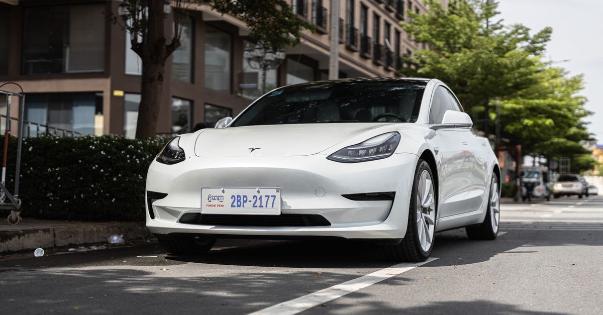 Alibaba's Qwen expands into Tesla vehicles, Baidu's Kunlun plugin, and enterprise speech AI A sleek white Tesla Model 3 parked on a city street under trees, showcasing modern automotive design.
