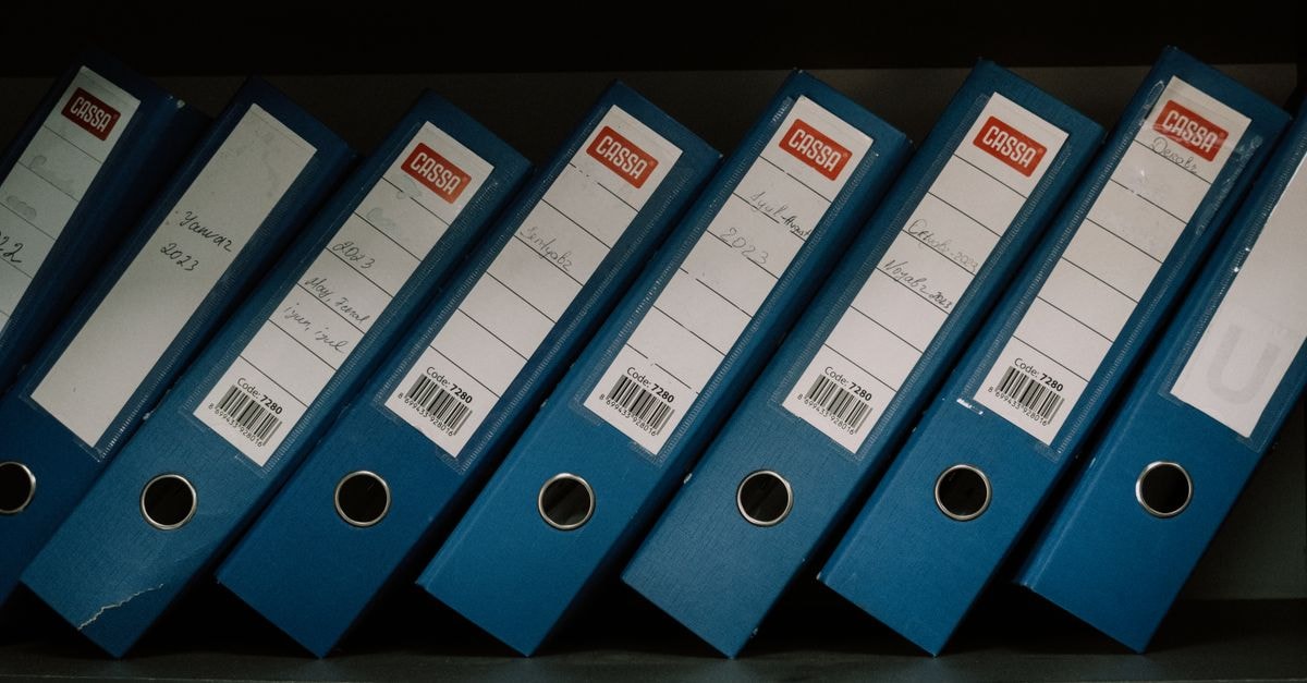 SK hynix weighs record shareholder returns Neatly arranged blue office binders labeled with dates and names for organized storage.