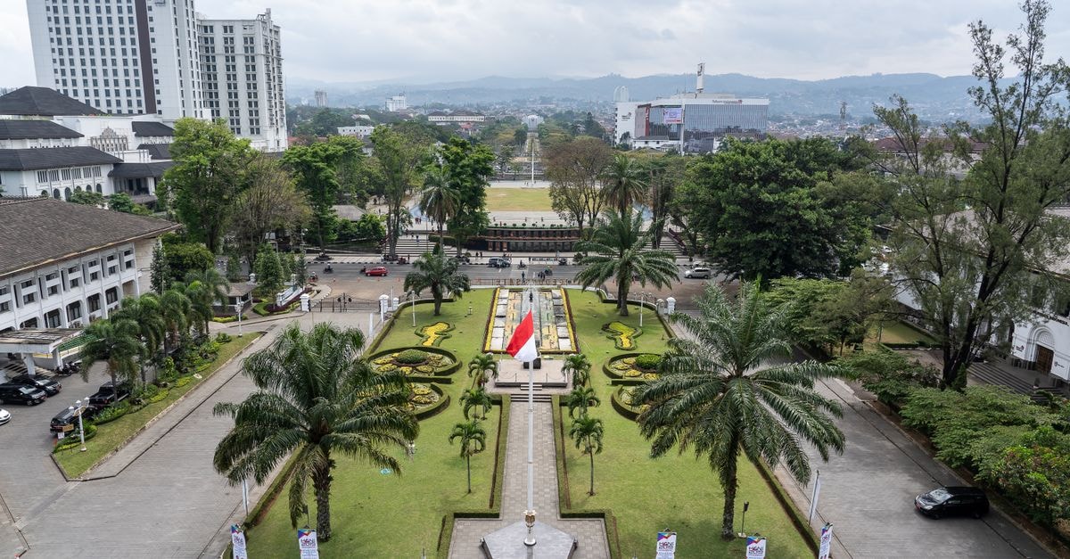 Mahalaya The Legacy Solo in Surakarta: A Heritage Stay at the Heart of the City A vibrant city park with palm trees and national flags from above.