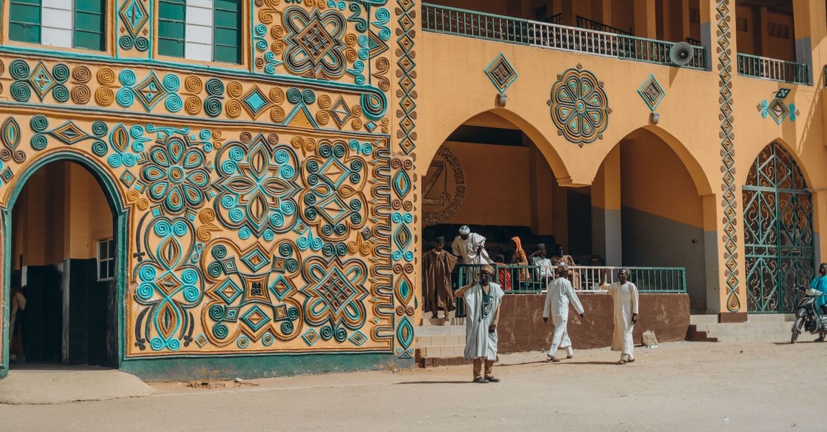 Vibrant African architecture with geometric patterns and people in traditional attire.